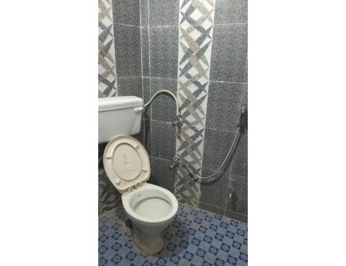 a bathroom with a white toilet in a room at Hotel Gaurishankar Palace, Barkot in Barkot