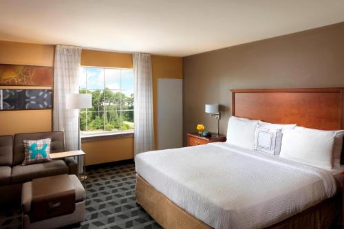 um quarto de hotel com uma cama grande e uma janela em TownePlace Suites Houston North/Shenandoah em The Woodlands