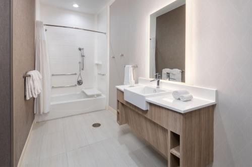 a bathroom with a sink and a shower and a tub at SpringHill Suites by Marriott Weatherford Willow Park in Willow Park