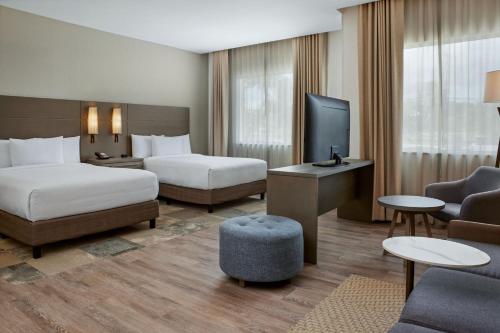 Cette chambre comprend deux lits et une télévision. dans l'établissement Residence Inn by Marriott Playa del Carmen, à Playa del Carmen