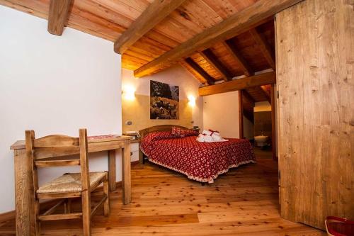 1 dormitorio con cama, escritorio y techo de madera en L'Or d'Echallogne - Chambre d'Hôtes en Arnad