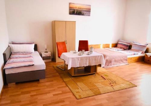Cette chambre comprend 2 lits et une table. dans l'établissement Ferienhof - Ferienwohnung, à Gadebusch