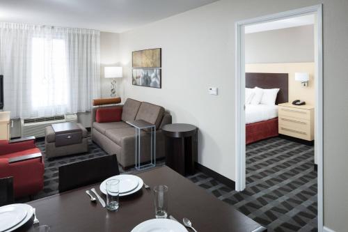 une chambre d'hôtel avec un canapé et un lit dans l'établissement TownePlace Suites Columbia Southeast / Fort Jackson, à Columbia