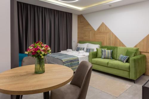 a living room with a green couch and a table at Inter Holiday Apartments in Pomorie