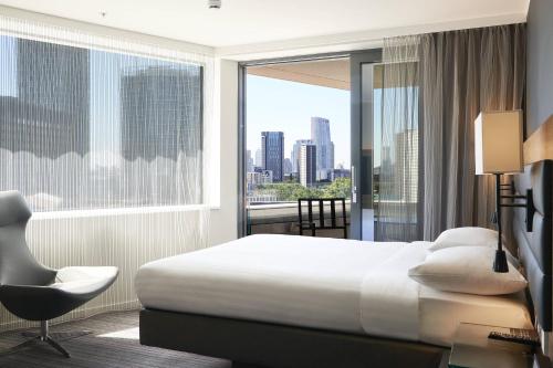 Habitación de hotel con cama y ventana grande en Moxy London Stratford en Londres