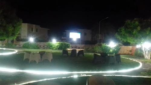 a park at night with lights in the grass at Villa with Roof, Private Garden and Backyard in North Coast - Families Only فيلا مستقلة الساحل الشمالي - عائلات فقط in Dawwār Abū Maḩrūs