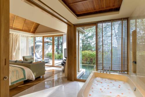 邁考海灘的住宿－普吉万丽度假酒店，主卧室配有浴缸和床。