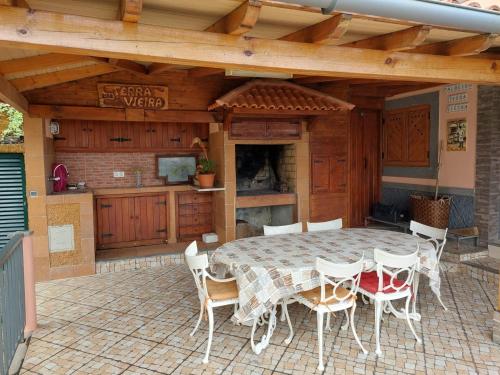 um pátio com uma mesa e cadeiras e uma cozinha em Fantatic Holiday House em Ponta Delgada