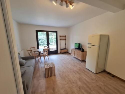 salon z kanapą, lodówką i stołem w obiekcie L'annexe, Village de l'Herbe w mieście Lège-Cap-Ferret
