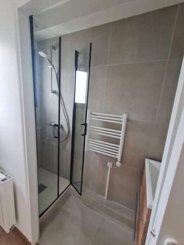 une douche avec une porte vitrée dans une salle de bain dans l'établissement L'annexe, Village de l'Herbe, à Lège-Cap-Ferret