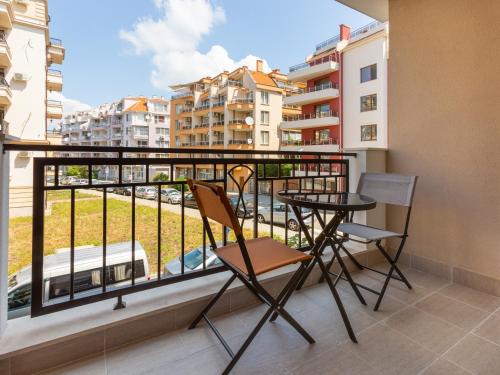 balkon ze stołem i krzesłami oraz widokiem na miasto w obiekcie Inter Holiday Apartments w mieście Pomorie