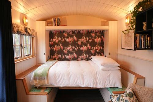 a bedroom with a bed with a floral wallpaper at Shepherds Hut in countryside near Bath and Bristol in Bristol