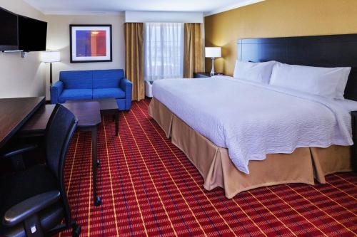 a hotel room with a large bed and a blue chair at TownePlace Suites by Marriott Corpus Christi in Corpus Christi