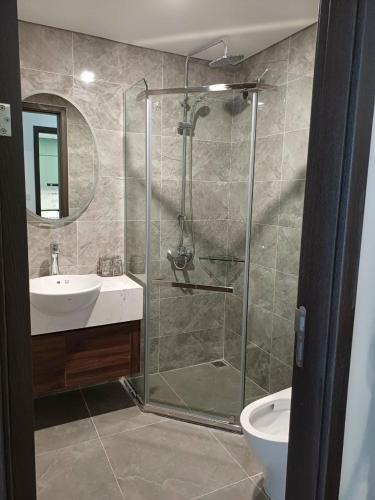 a bathroom with a shower and a sink and a toilet at Holiday Hotel in Hai Phong
