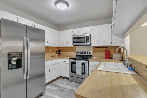 a kitchen with white cabinets and a stainless steel refrigerator at MiaBella of Hollywood home in Hollywood
