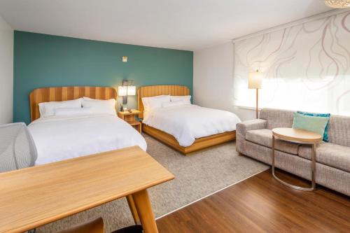una camera d'albergo con due letti e un divano di Element Bentonville a Bentonville