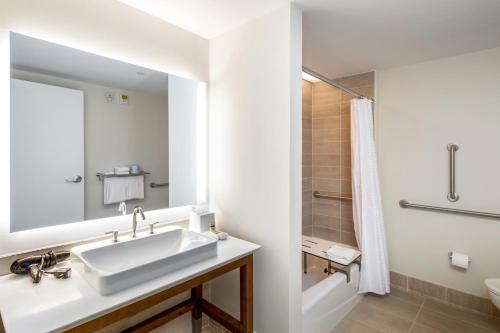 a white bathroom with a sink and a shower at Element Bentonville in Bentonville