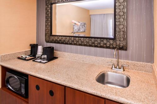 a bathroom with a sink and a microwave at Courtyard by Marriott Victorville Hesperia in Hesperia