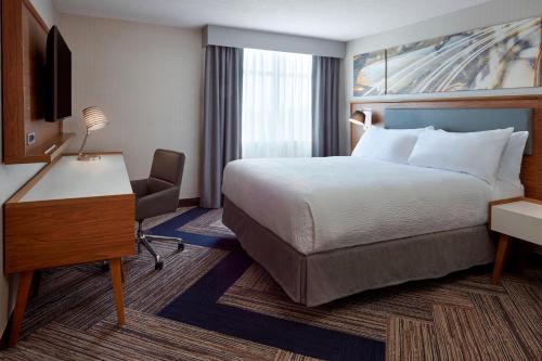 een hotelkamer met een bed en een bureau en een bed sidx sidx sidx sidx bij Four Points by Sheraton Hamilton - Stoney Creek in Hamilton