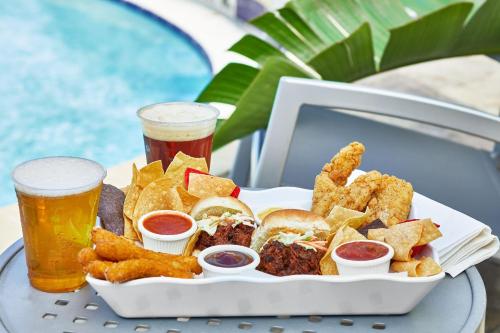 a tray of food with two beers and a plate of food at SpringHill Suites by Marriott Orlando at SeaWorld in Orlando