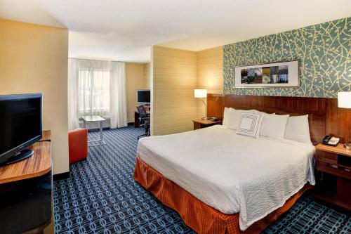 a hotel room with a bed and a flat screen tv at Fairfield by Marriott Southeast Hammond, IN in Hammond