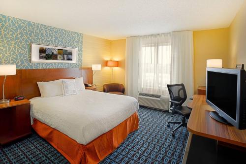 a hotel room with a bed and a flat screen tv at Fairfield by Marriott Southeast Hammond, IN in Hammond