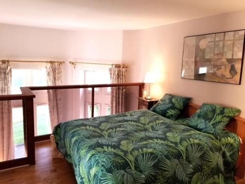 une chambre avec un lit avec une couverture verte dans l'établissement château de Beuzeval, golf de Hougate, à Gonneville-sur-Mer