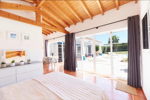 een slaapkamer met witte muren en een houten plafond bij Ocean Whisper in Aljezur