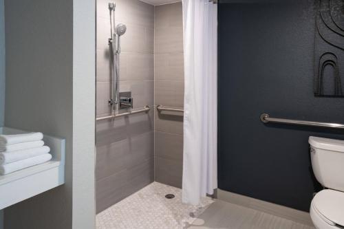 a bathroom with a toilet and a shower with towels at Marriott Jacksonville in Jacksonville