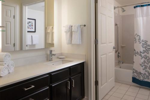 y baño con lavabo, espejo y bañera. en Residence Inn by Marriott Orlando at SeaWorld, en Orlando