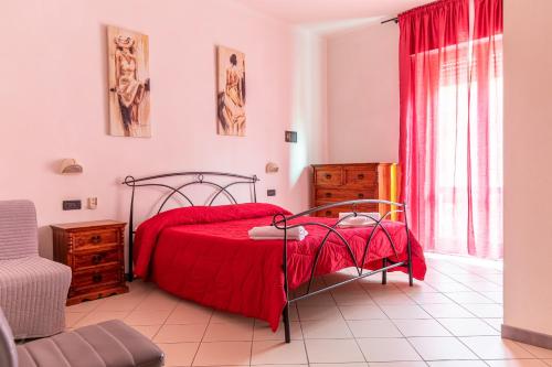 a bedroom with a red bed with a red blanket at Hotel Paolina in Viareggio