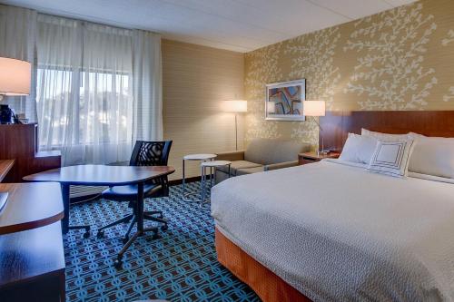 a hotel room with a bed and a table and chairs at Fairfield Inn Portsmouth Seacoast in Portsmouth