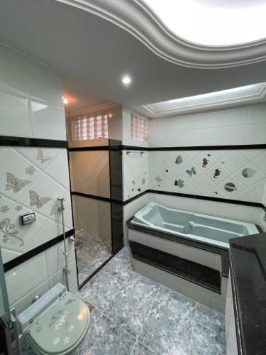 a bathroom with a bath tub and a toilet at Ap Beira mar na Orla in Aracaju