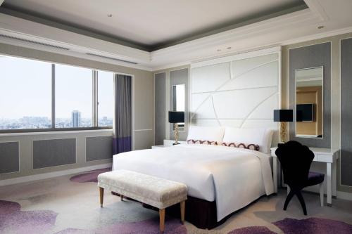 東京にある東京マリオットホテルのベッドルーム(大きな白いベッド1台、大きな窓付)