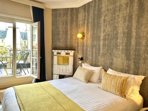 a bedroom with a bed and a window with a balcony at Beausejour Ranelagh in Paris
