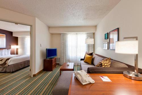 sala de estar con sofá y cama en Residence Inn Merrillville, en Merrillville