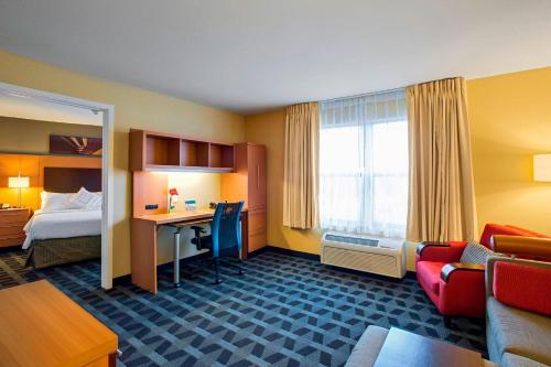 a hotel room with a bed and a desk at TownePlace Suites by Marriott Kansas City Overland Park in Overland Park