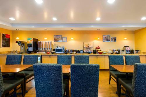 a restaurant with tables and chairs and a bar at TownePlace Suites by Marriott Kansas City Overland Park in Overland Park