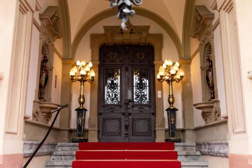een grote deur in een gebouw met rode loper bij Schloss Lieser, Autograph Collection in Lieser