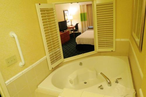 a bathroom with a tub and a room with a bed at Fairfield Inn & Suites Mount Vernon Rend Lake in Mount Vernon