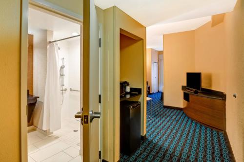 a hotel room with a door open to a bathroom at Fairfield Inn & Suites Christiansburg in Christiansburg