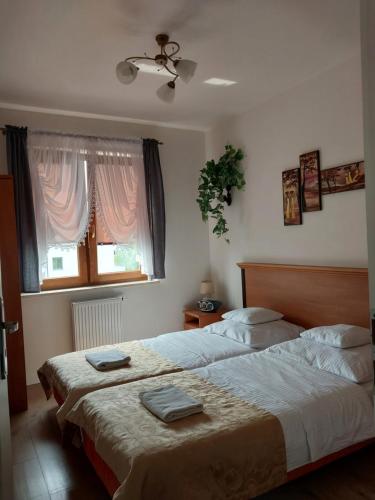 een slaapkamer met 2 bedden en een raam bij Telimena in Wyszków