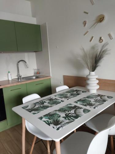 a kitchen with a white table and green cabinets at Telimena in Wyszków