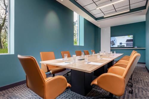 a conference room with a long table and chairs at Courtyard by Marriott Paris Charles de Gaulle Central Airport in Roissy-en-France