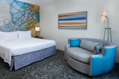 um quarto de hotel com uma cama e uma cadeira em Courtyard Kansas City Overland Park / Convention Center em Overland Park