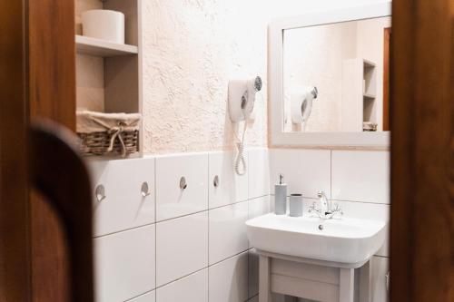 uma casa de banho branca com um lavatório e um espelho em Karczma Zacisze em Krutyń