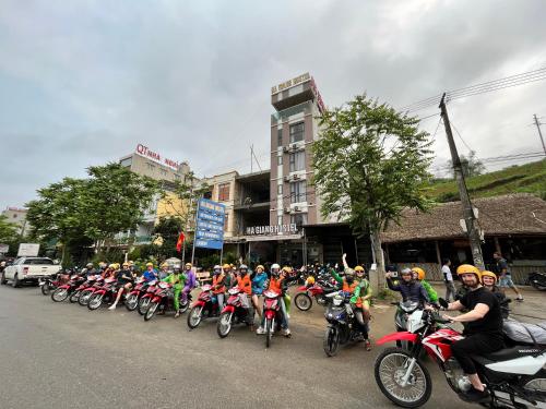 um grande grupo de pessoas andando de moto por uma rua em Ha Giang Hostel em Ha Giang