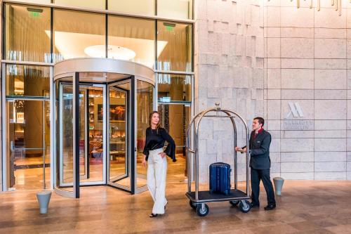 a man and a woman standing next to a luggage cart at Medellin Marriott Hotel in Medellín