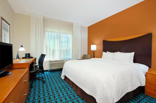 Habitación de hotel con cama, escritorio y TV. en Fairfield Inn & Suites Fort Lauderdale Airport & Cruise Port, en Dania Beach