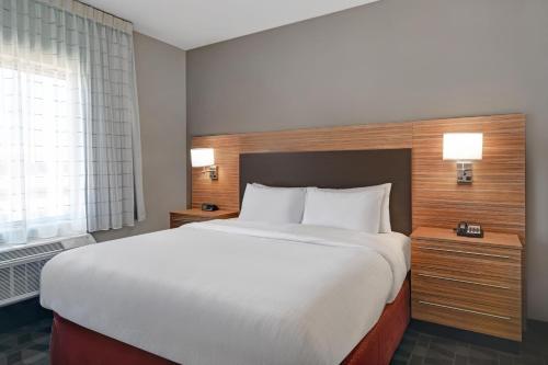 a bedroom with a large white bed and a window at TownePlace Suites by Marriott Grand Rapids Wyoming in Wyoming